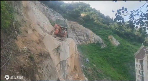 Excavator plummets off cliff