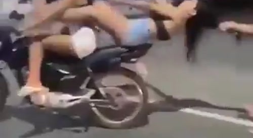 woman pulls another woman by the hair and hits her