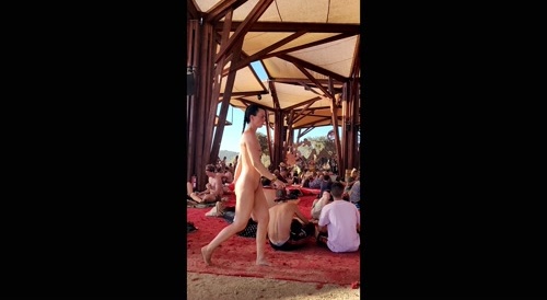 Girl walking naked in the middle of a crowd at festival