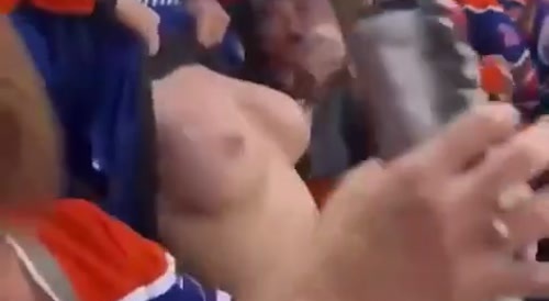 Woman exposes her breasts in hockey stadium.