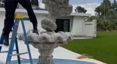 Girl kicks and falls on fountain base