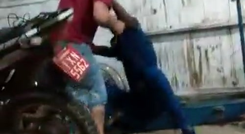 Men fight inside a workshop.