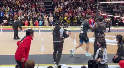 A Japanese volleyball play hitting someone with his serve
