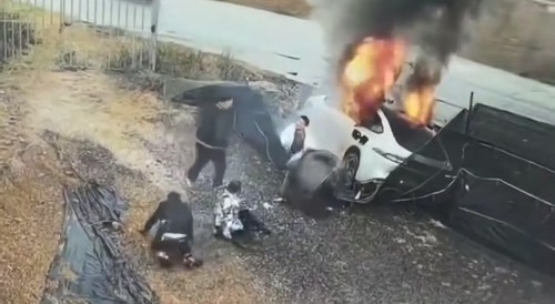 man pulls passengers out of burning car.
