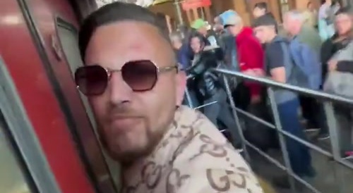 Man clings to the door of a still-moving subway to cut the line and get a seat.