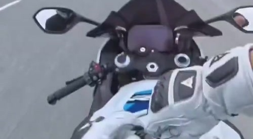 A motorcyclist fueled up his motorcycle while riding on the road